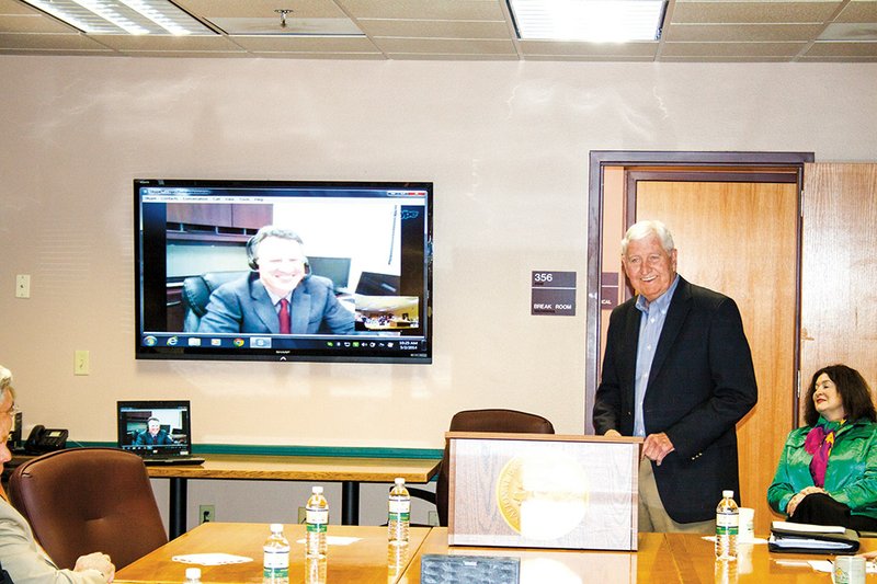 John Hogan, on screen, speaks to the Board of Trustees of National Park Community College after his selection as the new president of the college was announced by Board Chairman Mike Bush on Friday in Hot Springs. Hogan, vice president of student affairs for the Ivy Tech Community College System in Indiana, said he and his family are excited about his new job in Arkansas. His wife is a graduate of Harding University, and one of his sons is a sophomore at the school in Searcy.