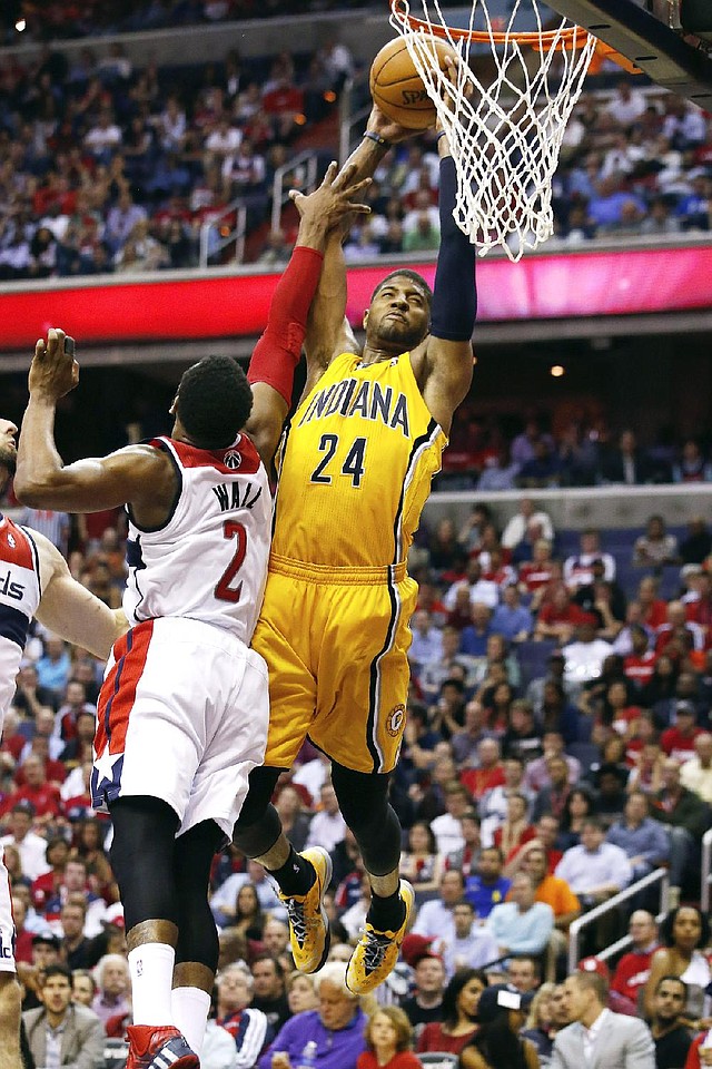 Indiana Pacers forward Paul George (24) shoots for two points under pressure from Washington Wizards guard John Wall (2) during the second half of Game 3 of an Eastern Conference semifinal NBA basketball playoff game in Washington, Friday, May 9, 2014. (AP Photo/Alex Brandon)