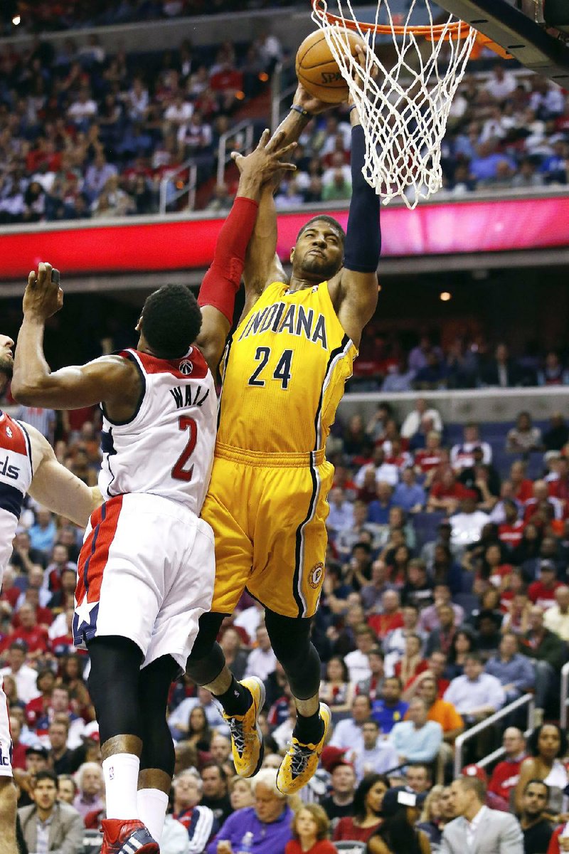 Indiana Pacers forward Paul George (24) shoots for two points under pressure from Washington Wizards guard John Wall (2) during the second half of Game 3 of an Eastern Conference semifinal NBA basketball playoff game in Washington, Friday, May 9, 2014. (AP Photo/Alex Brandon)