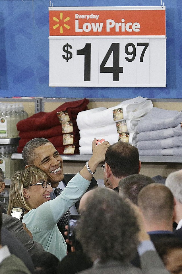 President Barack Obama poses for a selfie photo after speaking at a Walmart store in Mountain View, Calif., Friday, May 9, 2014. Obama announced new steps by companies, local governments and his own administration to deploy solar technology, showcasing steps to combat climate change that don't require consent from a disinclined Congress. (AP Photo/Jeff Chiu)