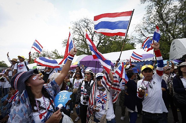 Anti-government protesters wave Thai national flags during a rally in downtown Bangkok, Thailand, Friday, May 9, 2014. Thailand's anti-graft commission indicted ousted Prime Minister Yingluck Shinawatra on Thursday on charges of dereliction of duty in overseeing a widely criticized rice subsidy program, a day after a court forced her from office. Yingluck was accused of allowing the rice program, a flagship policy of her administration, to proceed despite advice that it was potentially wasteful and prone to corruption. (AP Photo/Vincent Thian)