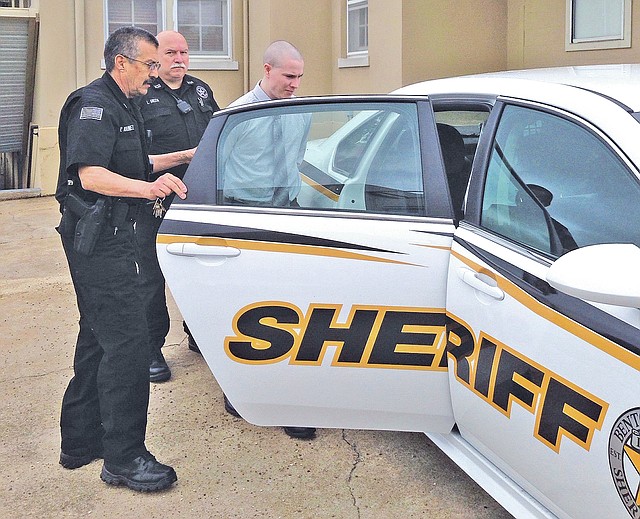 STAFF PHOTO Tracy Neal Benton County Sheriff&#8217;s Office deputies put Zachary Holly into a patrol car to return to the Benton County Jail after a court appearance Friday morning in Bentonville.