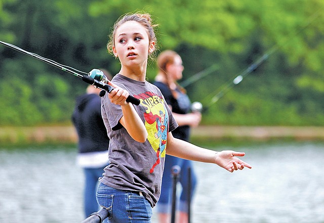 STAFF PHOTO JASON IVESTER Mary Hadley WIlliams, an Elmwood Middle School eighth-grader, casts into Lake Atalanta on Friday in Rogers. A group of eighth-graders from the Rogers school came to the park and received fishing lessons from professional angler Randy Howell as part of Casting Kids, a program sponsored by Bass Anglers Sportsman Society and Walmart.