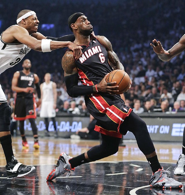 Miami Heat forward LeBron James gets fouled from behind by Brooklyn’s Paul Pierce in the Nets’ 104-90 victory Saturday night. James scored 28 points and grabbed 8 rebounds while Pierce had 14 points and 4 rebounds. 