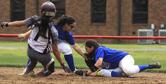 Bald Knob 9, Perryville 3 Perryville’s Lacy Alford slides into second base as Bald Knob’s Brooke Mason (center) and Britain Brooks fumble for the ball during Saturday’s Class 3A Region 2 game at Haskell. 