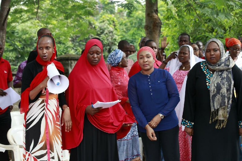 Women attend a rally calling on the Government to rescue the school girls kidnapped from the Chibok Government secondary school, in Abuja, Nigeria, Saturday May 10, 2014. The president of Nigeria for weeks refused international help to search for more than 300 girls abducted from a school by Islamic extremists, one in a series of missteps that have led to growing international outrage against the government. The waiting has left parents in agony, especially since they fear some of their daughters have been forced into marriage with their abductors for a nominal bride price of $12. Boko Haram leader Abubakar Shekau called the girls slaves in a video this week and vowed to sell them. "For a good 11 days, our daughters were sitting in one place," said Enoch Mark, the anguished father of two girls abducted from the Chibok Government Girls Secondary School. "They camped them near Chibok, not more than 30 kilometers, and no help in hand. For a good 11 days." (AP Photo/Sunday Alamba)