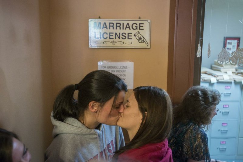 STAFF PHOTO ANTHONY REYES
Kristin Seaton, left, and Jennifer Rambo, kiss while waiting for their marriage license Saturday, May 10, 2014 at the Carroll County Courthouse in Eureka Springs. The office closed shortly after opening telling those waiting in line to leave, but opened at 10 a.m. and issued the first marriage license to a same-sex couple in Arkansas.