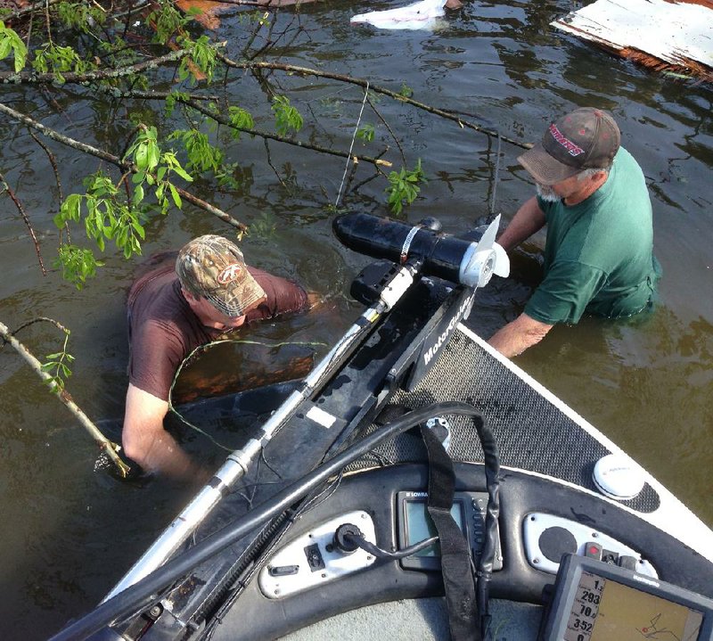 David Short (right) and Steve Howard wrap a towing strap around the safe after it was found submerged in Lake Conway. 
