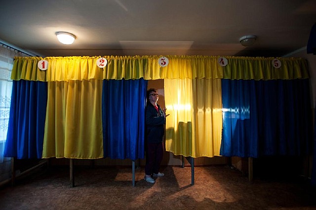 An election official prepares voting booths Saturday at a poll station in Mariupol, Ukraine, ahead of a regional referendum today. 