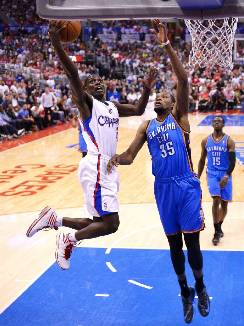 Los Angeles Clippers guard Darren Collison, left, puts up a shot as Oklahoma City Thunder forward Kevin Durant, center, defends and guard Reggie Jackson looks on in the second half of Game 4 of the Western Conference semifinal NBA basketball playoff series, Sunday, May 11, 2014, in Los Angeles. The Clippers won 101-99. (AP Photo/Mark J. Terrill)