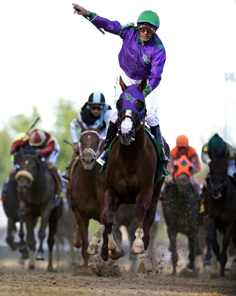 FILE - In this May 3, 2014, file photo, jockey Victor Espinoza celebrates aboard California Chrome after winning the 140th running of the Kentucky Derby horse race at Churchill Downs in Louisville, Ky. The California colt will be running in the Preakness with a bulls-eye on his back as perhaps racing's next superstar. He figures to face eight or nine rivals in the middle leg of the Triple Crown series, and one of them might be a filly.  (AP Photo/David J. Phillip, File)