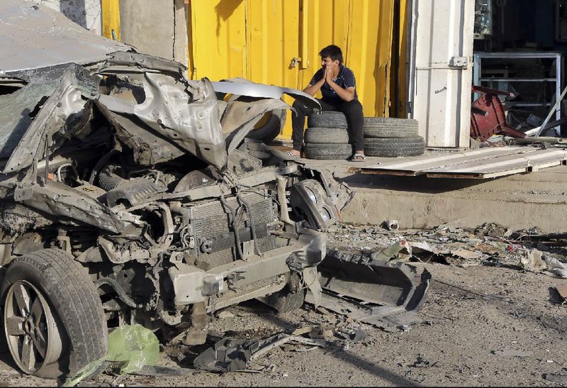 A man sits in front of his shop that was damaged in a Saturday car bomb attack near a Kebab restaurant, in the mainly Shiite Habibiya neighborhood of Baghdad, Iraq, Sunday, May 11, 2014. A series of bombings on Saturday in Iraq killed and wounded scores of people, a day after army shelling killed many civilians and gunmen in the militant-held city of Fallujah, authorities said. (AP Photo/Karim Kadim)