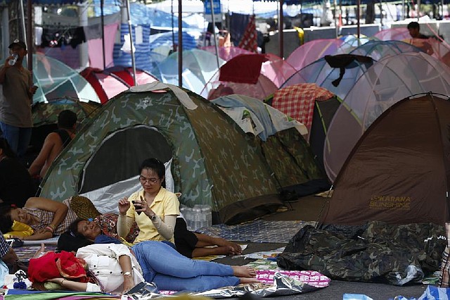 Anti-government protesters rest at a camp site in downtown Bangkok, Thailand, Sunday, May 11, 2014. Thai anti-government protesters who have been camped out in several locations in Bangkok packed their tents as they ramped up their efforts to bring down what remains of Prime Minister Yingluck Shinawatra's administration by laying siege to television stations, surrounding state offices and demanding lawmakers help them install a non-elected prime minister to rule the country. (AP Photo/Vincent Thian)