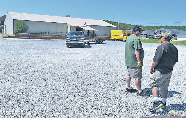 STAFF PHOTO Michael Woods &#8226; @NWAMICHAELW Brad Smith, left, and Robert Hagan, with the Greenland maintenance department, work on helping local residents during the annual spring cleaning event in the parking lot of the Community Center on Saturday afternoon in Greenland. Greenland and Elkins received about $20,000 in grants from the state for rural development and projects. Greenland is going to be using theirs to fix up the town&#8217;s community center, give it a new roof and a generator.