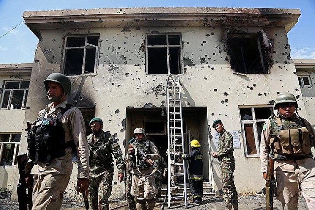 Afghan security personnel surround the area after Taliban fighters stormed a government building in Jalalabad, east of Kabul, Afghanistan, Monday, May 12, 2014. Taliban fighters stormed a government building in eastern Afghanistan killing police guards on Monday, the most serious in a wave of attacks marking the start of the insurgents' annual spring offensive. In the Taliban heartland in the south, an attack on a police checkpoint in Helmand province killed many policemen. (AP Photo/Rahmat Gul)