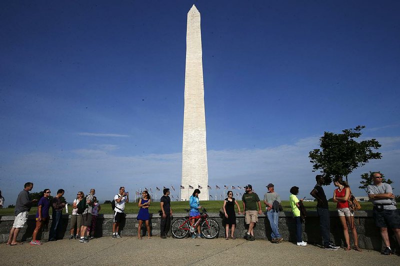 Visitors line up for tickets which are distributed at on a first-come basis at the Washington Monument in Washington, Monday, May 12, 2014, ahead of a ceremony to celebrate its re-opening. The monument, which sustained damage from an earthquake in August 2011, is reopening to the public today. (AP Photo)