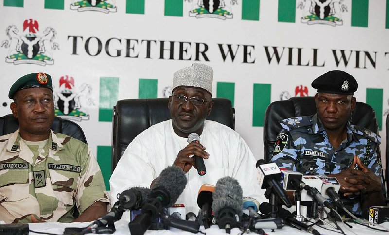 Brig. Gen. Chris Olukolade, Nigeria's top military spokesman,left, Director General, National Orientation Agency, Mike Omeri, centre, Frank Mba National police spokesman, right, attend a press conference on the abducted school girls in Abuja, Nigeria, Monday, May 12, 2014. A Nigerian Islamic extremist leader says nearly 300 abducted schoolgirls will not be seen again until the government frees his detained fighters. A new video from Nigeria's homegrown Boko Haram terrorist network received Monday purports to show some of the girls and young women chanting Quranic verses in Arabic. The barefoot girls look frightened and sad and sit huddled together wearing gray Muslim veils. Some Christians among them say they have converted to Islam. (AP Photo/Sunday Alamba)