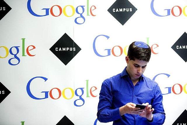 A visitor uses his phone at Google Inc.’s London office in this December photo. The European Court of Justice ruled Tuesday that Google must give users of its search engine a right to delete links about themselves. 