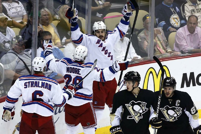 New York’s Brian Boyle (center) celebrates his first-period goal along with teammates Anton Stralman (6) and Dominic Moore during Tuesday night’s 2-1 victory over Pittsburgh. The Rangers won the series and advanced to the conference finals where they will face either Boston or Montreal. 