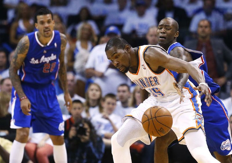Los Angeles Clippers guard Jamal Crawford (right) knocks the ball away from Oklahoma City’s Kevin Durant in the second quarter of the Thunder’s 105-104 victory Tuesday night in Oklahoma City. Durant scored 27 points. 