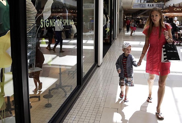 A shopper and her son pass a store in the Aventura Mall in Aventura, Fla., in March. The Commerce Department said retail sales rose just 0.1 percent last month, after rising 1.5 percent in March. 