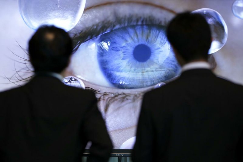 Visitors at Sony Corp.’s headquarters in Tokyo on Wednesday look at a liquid crystal display television. Sony reported a loss of $1.3 billion Wednesday for the fourth quarter. 