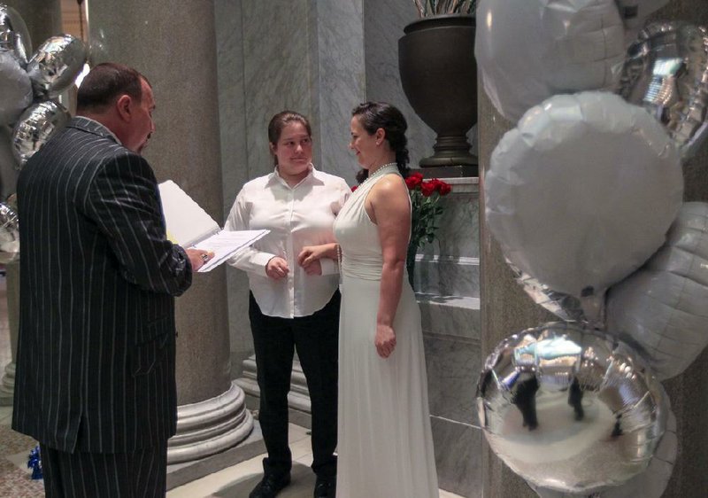 Randy Eddy-McCain officiates a wedding Wednesday for Lauren Zavelli and Mary Sorrels in the Pulaski County Courthouse rotunda in Little Rock. 