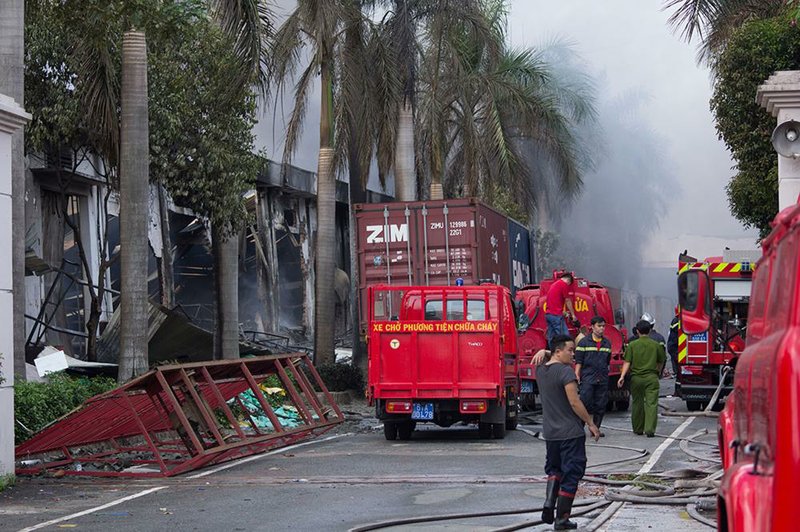 Firefighters watch as a Taiwanese bicycle factory burns Wednesday after anti-China rioting at an industrial park in Vietnam’s Binh Duong province. 