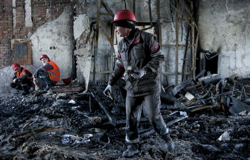 Steelworkers clear away debris Friday in a government building in the eastern Ukrainian city of Mariupol after billionaire Rinat Akhmetov urged his employees to help restore order. 