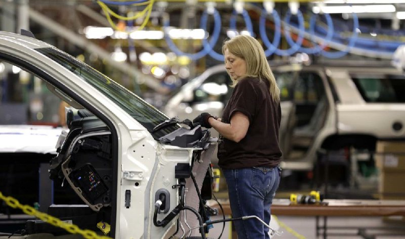An auto worker assembles an SUV at the General Motors auto plant in Arlington, Texas, Tuesday, May 13, 2014. (AP Photo/LM Otero)