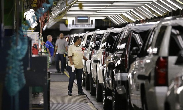 An autoworker inspects finished sport utility vehicles Tuesday at the General Motors plant in Arlington, Texas. GM has recalled more than 11 million vehicles since January.

