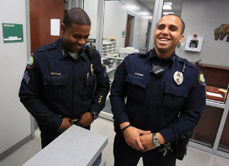 Little Rock Police Sgt. Brian Grigsby (left) and officer Troy Dillard recount Thursday their actions Saturday when they helped an 83-year-old man with dementia buy Mother’s Day flowers for his wife. The man had been reported missing and when the officers found him, he said he had to buy flowers. They took him to two stores to find the right flowers and even helped pay some of the tab. 