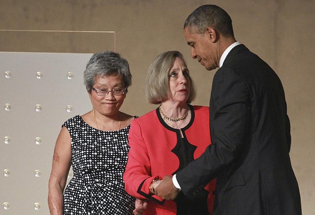 President Barack Obama greets Ling Young (left) and Alison Crowther during the dedication ceremony Thursday at the National September 11 Memorial Museum in New York. Crowther’s son, Welles, saved Young’s life during the collapse of the twin towers, but died himself. 