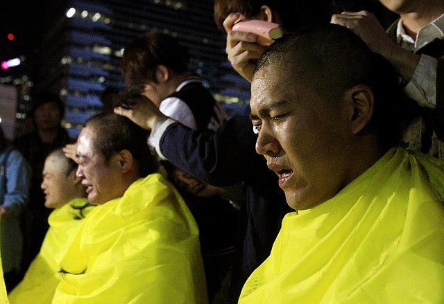 College students have their heads shaved during a rally to call for thorough investigations into the sunken ferry Sewol in Seoul, South Korea, Thursday, May 15, 2014. Prosecutors indicted the captain of the sunken South Korean ferry and three crew members on homicide charges Thursday, alleging that they failed to carry out their duties to protect passengers in need.  (AP Photo/Ahn Young-joon)