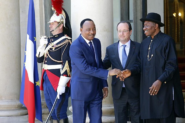 Niger's President Mahamadou Issoufou, left shakes hands with Nigeria's President Goodluck Jonathan, right, as French President Francois Hollande, center, looks on upon his arrival for the "Paris' Security in Nigeria summit", at the Elysee Palace, in Paris, Saturday, May 17, 2014. Leaders from Africa as well as officials from the United States, Britain and France meet to coordinate a response to Boko Haram, the fundamentalist group that abducted more than 300 girls and is accused of hundreds of deaths in the past year alone. (AP Photo/Francois Mori)