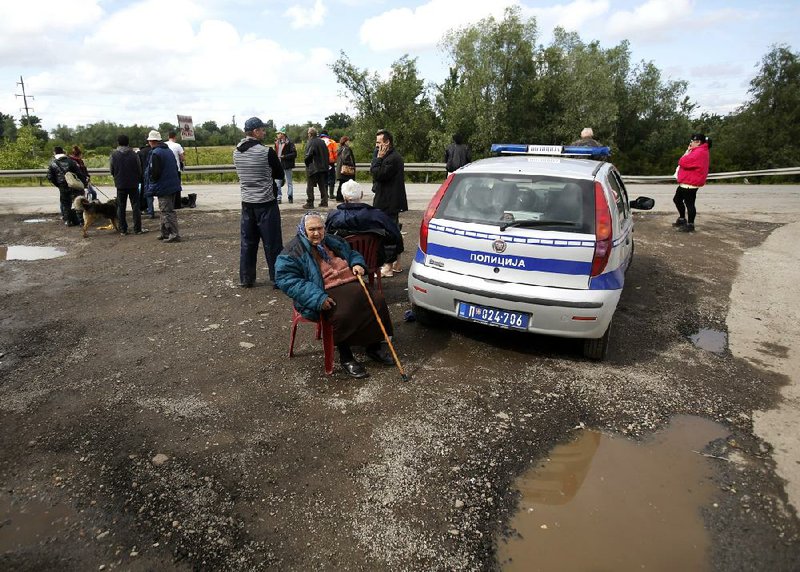 People wait for transport during evacuation from Obrenovac, some 30 kilometers (18 miles) southwest of Belgrade Serbia, Saturday, May 17, 2014. Record flooding in the Balkans leaves at least 20 people dead in Serbia and Bosnia and is forcing tens of thousands to flee their homes. Meteorologists say the flooding is the worst since records began 120 years ago. (AP Photo/Darko Vojinovic)