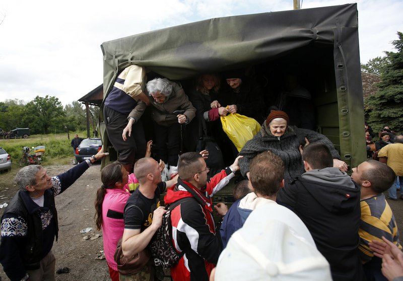 People help old women out of a military truck during evacuation from Obrenovac, some 18 miles southwest of Belgrade Serbia, Saturday, May 17, 2014. Record flooding in the Balkans leaves at least 20 people dead in Serbia and Bosnia and is forcing tens of thousands to flee their homes. Meteorologists say the flooding is the worst since records began 120 years ago.