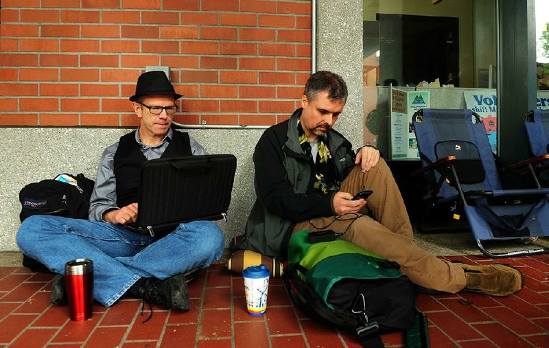 Ken Brashier (L) and Andrew Wallace (R) pass the time in front of the Multnomah County Recorder's building in Portland, Or. on Monday, May. 19, 2014. The two are awaiting a ruling in the Marriage Equality case, so they can go into the building and get their marriage licenses. A ruling in that case is expected on Monday. (AP Photo/Steve Dykes)