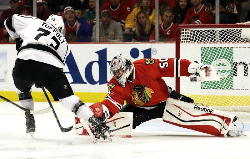 Chicago Blackhawks goalie Corey Crawford, right, blocks a shot by Los Angeles Kings' Tyler Toffoli (73) during the third period of Game 1 of the Western Conference finals in the NHL hockey Stanley Cup playoffs in Chicago on Sunday, May 18, 2014. The Blackhawks won 3-1. (AP Photo/Nam Y. Huh)