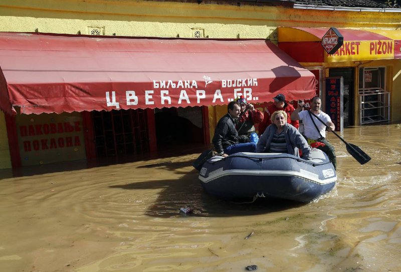 Volunteers use a rubber boat to evacuate residents from a flooded area in Obrenovac, some 30 kilometers (18 miles) southwest of Belgrade, Serbia, Sunday, May 18, 2014. In Serbia, more than 20,000 people have been forced from their homes. Officials there fear more flooding later Sunday as floodwaters travel down the Sava and reach the country. Serbian officials said that the flood wave might be lower than initially expected, because the river broke barriers upstream in Croatia and Bosnia. Experts said they expect Sava floodwaters to rise for two more days, then subside. (AP Photo/Darko Vojinovic)