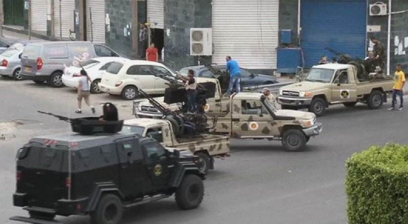 In this image made from video provided by the Libyan national army via AP Television, Tripoli joint security forces on vehicles with heavy artillery stand guard on the entrance road to the parliament area after troops of Gen. Khalifa Hifter targeted Islamist lawmakers and officials at the parliament in Tripoli, Libya, Sunday, May 18, 2014. Forces loyal to a rogue Libyan general attacked the country's parliament Sunday, expanding his eastern offensive against Islamists into the heart of the country's capital. (AP Photo/Libyan national army)