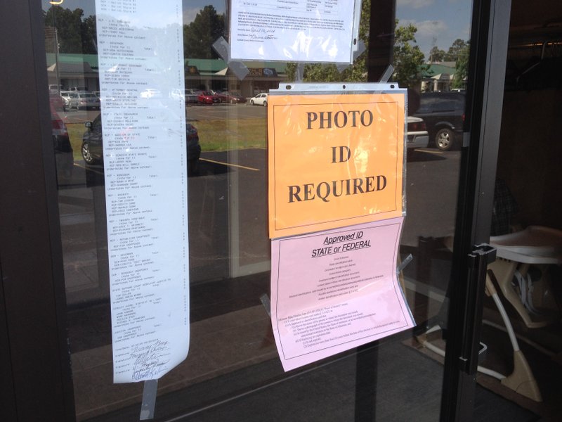 A sign on the door at a polling site at First Church Of the Nazarene in Hot Springs informs voters they must show ID to cast a ballot.