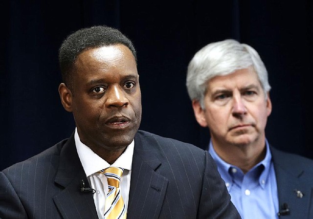 Detroit emergency manager Kevyn Orr (left) addresses a news conference in Detroit as Michigan Gov. Rick Snyder, who appointed Orr, listens in this March 14, 2013, photo. The conservative Americans for Prosperity organization is launching an effort to kill the legislative appropriation that is the key to Detroit’s bankruptcy settlement. 