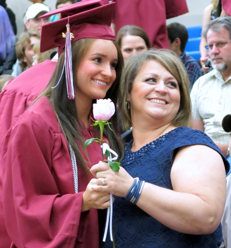 Photo by Randy Moll Gentry senior Aspen Cripps presents a flower to her mother, Marnie Cripps, during Gentry High School graduation ceremonies on Friday at the Bill George Arena in Siloam Springs.