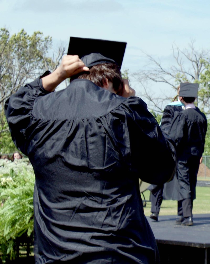 Grads battled the stiff breeze to keep their caps in place.