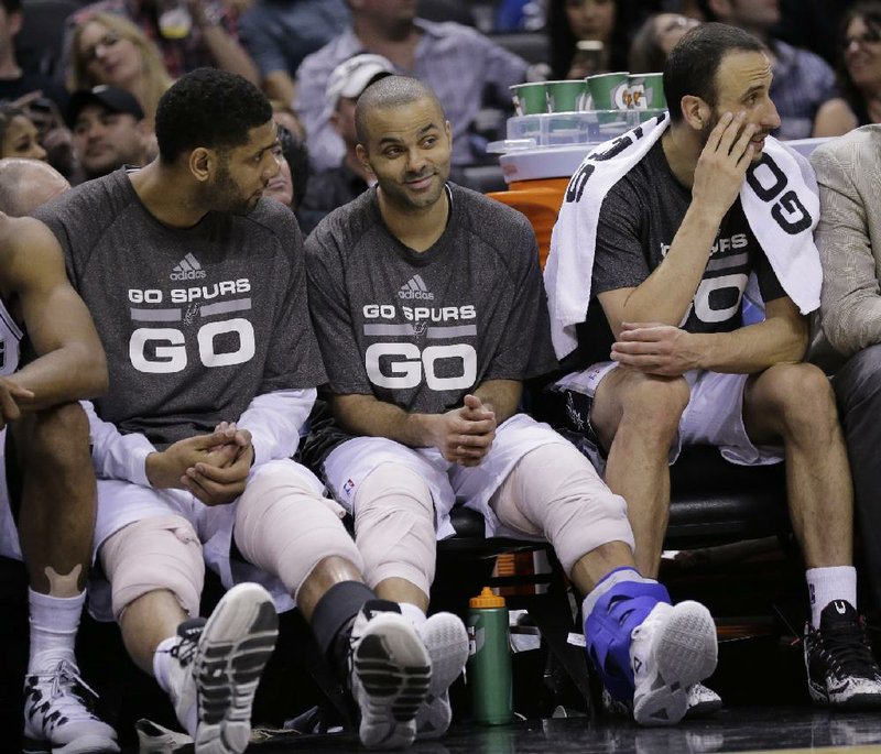 San Antonio starters Tim Duncan (left) and Tony Parker rest on the bench Wednesday during the second half of the Spurs’ 112-77 victory over Oklahoma City in San Antonio. 