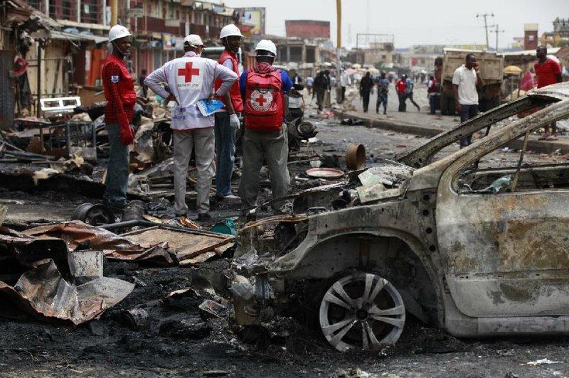 Red Cross workers on Wednesday search the site where a car bomb went off Tuesday in Jos, Nigeria, one of two bombings that day that left 130 people dead. 