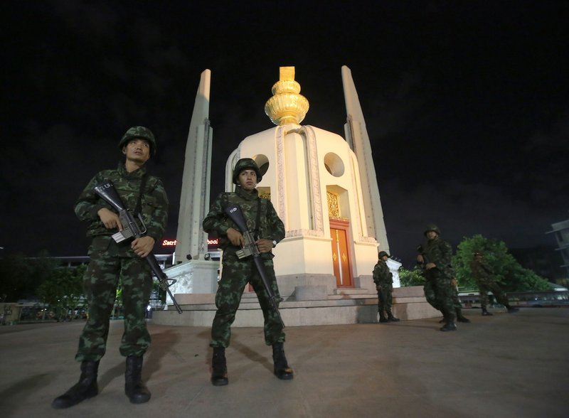 Thai soldiers stand guard in front of the Democracy Monument after the coup Thursday, May 22, 2014 in Bangkok, Thailand. Thailand's military seized power Thursday in a bloodless coup, dissolving the government, suspending the constitution and dispersing groups of protesters from both sides of the country's political divide who had gathered in Bangkok and raised fears of a violent showdown.