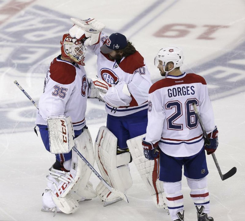 Montreal Canadiens goalie Peter Budaj (center) congratulates fellow goalie Dustin Tokarski on Thursday after the Canadiens’ 3-2 overtime victory over the New York Rangers in Game 3 of the NHL’s Eastern Conference Final. The Rangers lead the series 2-1. 