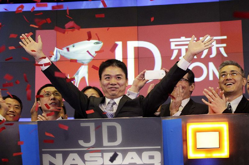 Qiangdong Liu, CEO of JD.com, raises his arms to celebrate the IPO for his company at the Nasdaq MarketSite, Thursday, May 22, 2014 in New York. JD.com, China's No. 2 e-commerce service, is headquartered in Beijing. (AP Photo/Mark Lennihan)